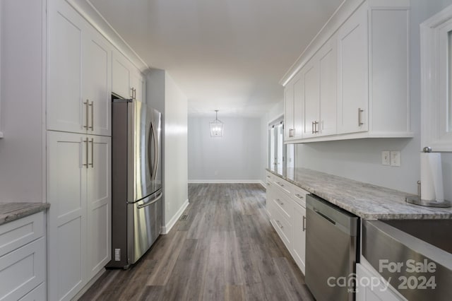 kitchen with dark hardwood / wood-style floors, stainless steel appliances, pendant lighting, white cabinetry, and light stone counters