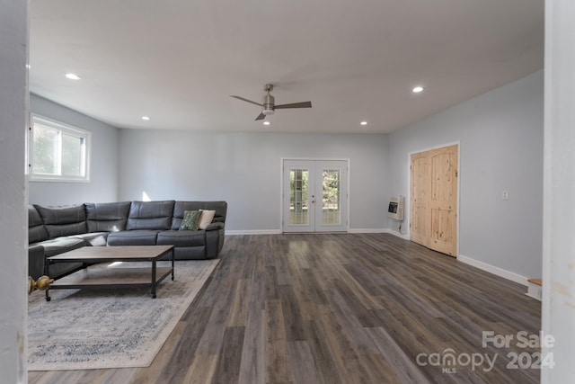 living room with dark wood-type flooring, heating unit, french doors, and ceiling fan