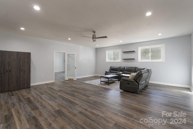 living room featuring ceiling fan and dark hardwood / wood-style flooring