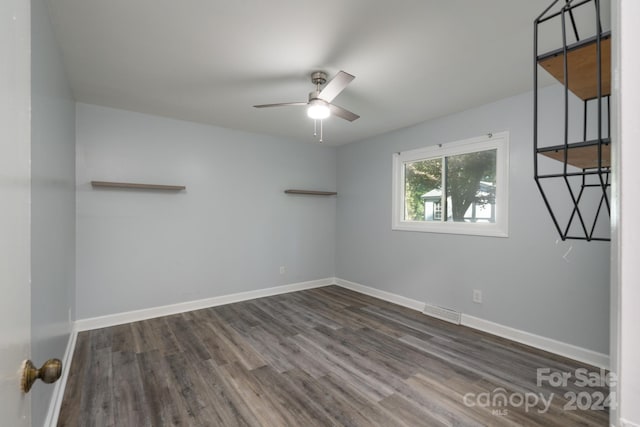 empty room featuring ceiling fan and dark hardwood / wood-style flooring