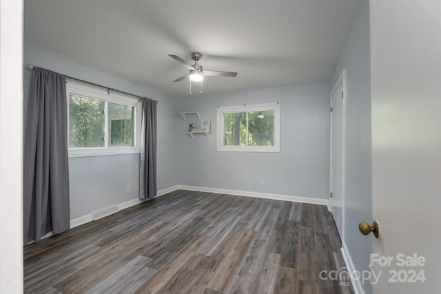 empty room featuring dark wood-type flooring and ceiling fan