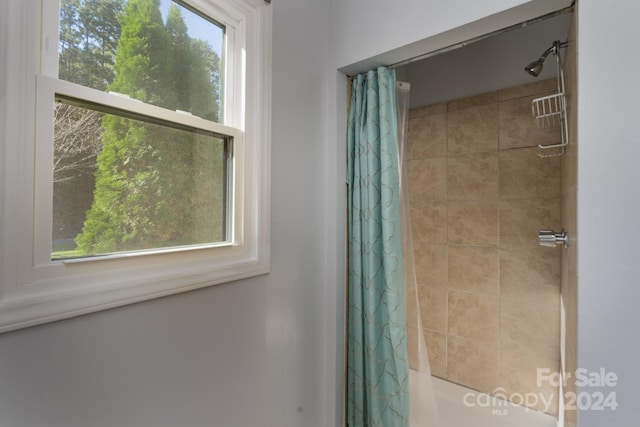 bathroom with shower / bath combination with curtain and plenty of natural light