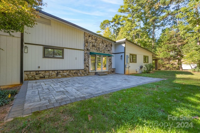 back of property with a patio and a lawn