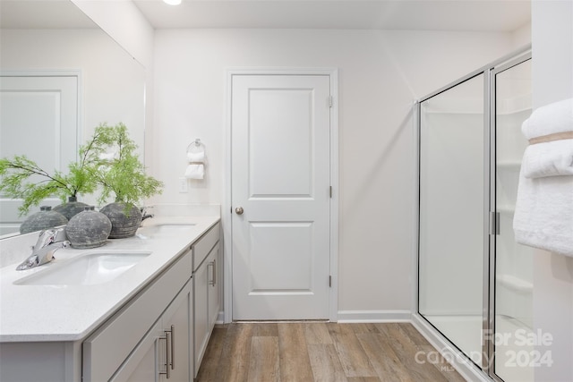 bathroom with vanity, hardwood / wood-style flooring, and a shower with shower door