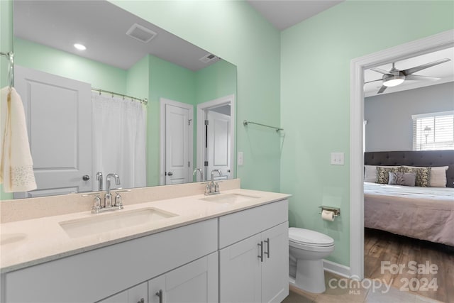 bathroom with vanity, wood-type flooring, toilet, and ceiling fan