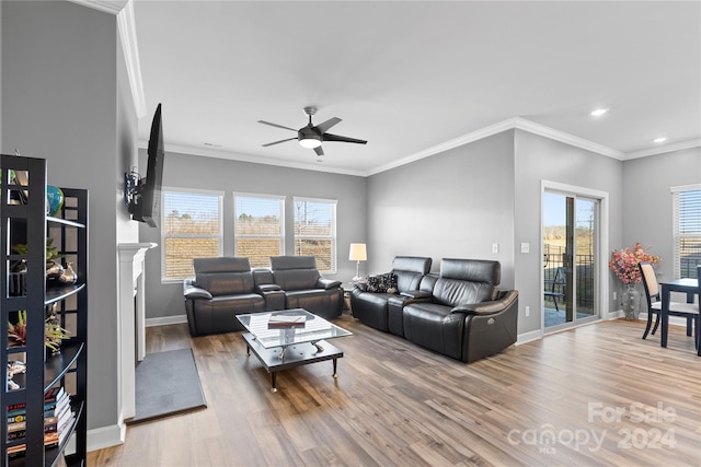 living room featuring ornamental molding, wood-type flooring, and a healthy amount of sunlight