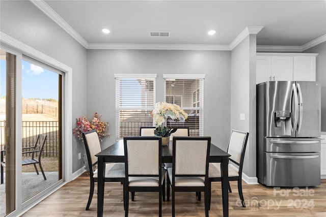 dining space featuring crown molding and light wood-type flooring