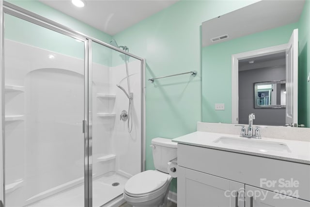 bathroom with vanity, toilet, and an enclosed shower