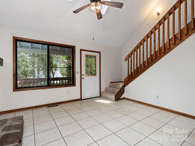 entryway with ceiling fan, vaulted ceiling, and light tile patterned flooring