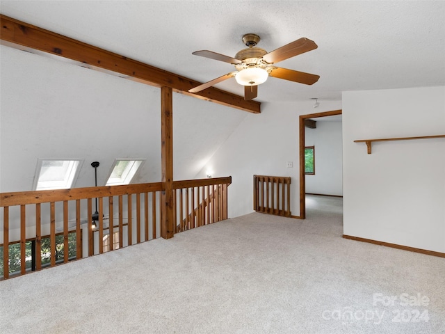 additional living space featuring ceiling fan, a textured ceiling, carpet flooring, and vaulted ceiling with skylight