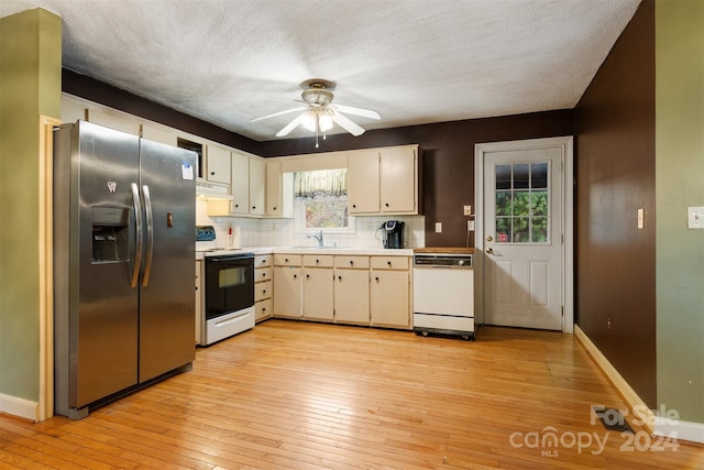 kitchen featuring sink, tasteful backsplash, a textured ceiling, white appliances, and light wood-type flooring