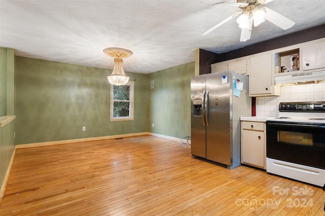 kitchen featuring stainless steel refrigerator with ice dispenser, white range oven, hanging light fixtures, white cabinets, and light wood-type flooring