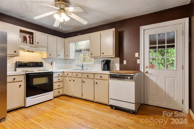 kitchen featuring light wood-type flooring, decorative backsplash, sink, white appliances, and ceiling fan