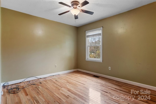 unfurnished room with ceiling fan, a textured ceiling, and light hardwood / wood-style flooring