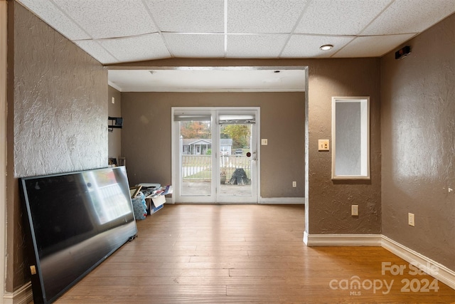 entrance foyer featuring light wood-type flooring, a paneled ceiling, and crown molding