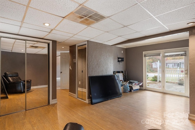 interior space featuring wood-type flooring and a drop ceiling