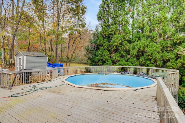 view of swimming pool featuring a storage shed and a wooden deck