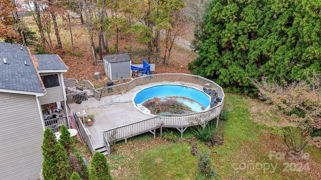 view of swimming pool with a deck and a storage shed