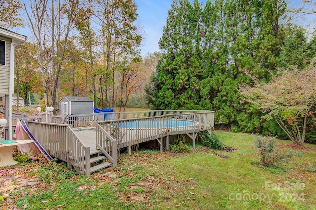 view of pool with a wooden deck and a storage shed