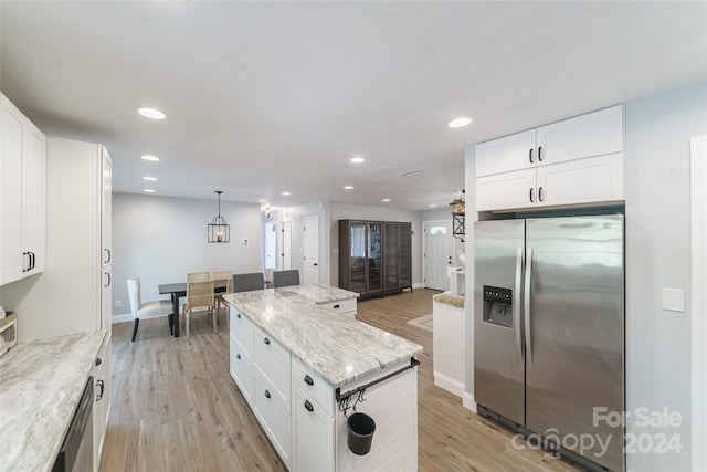 kitchen featuring light wood-type flooring, a kitchen island, white cabinetry, light stone counters, and stainless steel refrigerator with ice dispenser