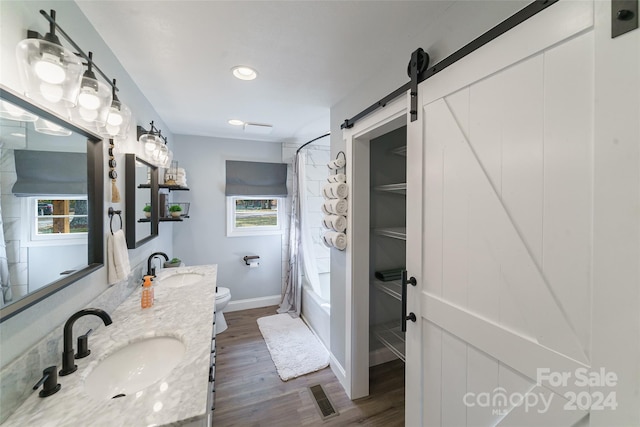 full bathroom featuring toilet, hardwood / wood-style floors, shower / bath combo, and a wealth of natural light