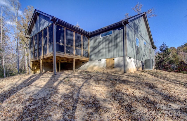 back of house featuring central air condition unit and a sunroom