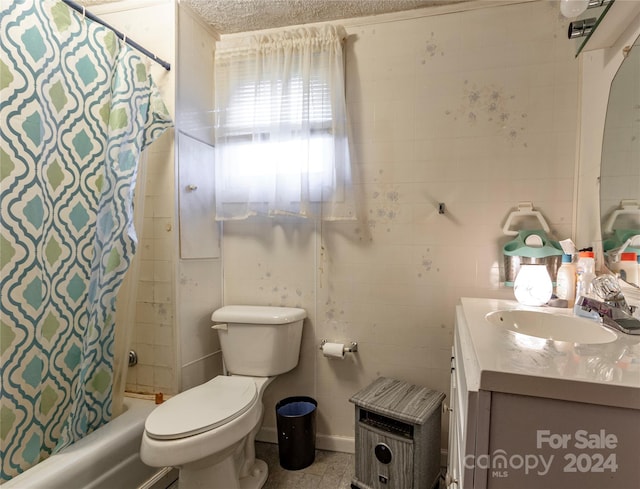 full bathroom with vanity, shower / tub combo, a textured ceiling, and toilet