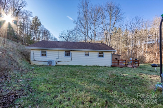 back of property with a wooden deck and a yard