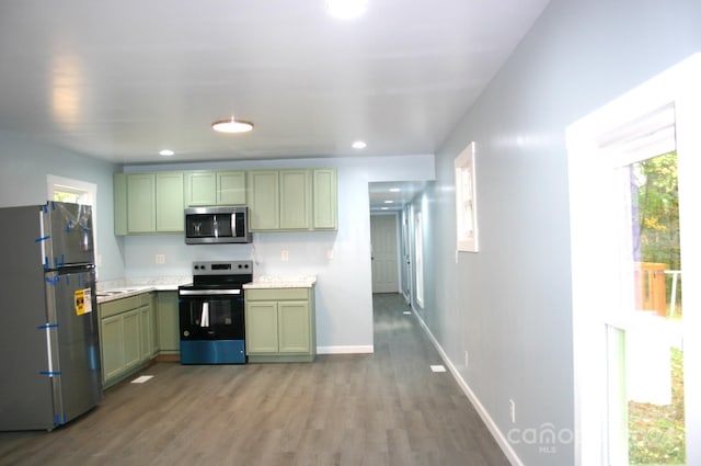 kitchen featuring sink, green cabinetry, stainless steel appliances, and hardwood / wood-style flooring