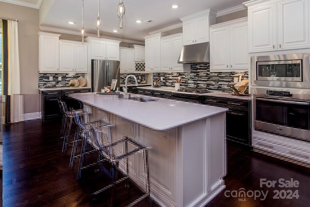 kitchen with a center island with sink, sink, white cabinetry, and stainless steel appliances