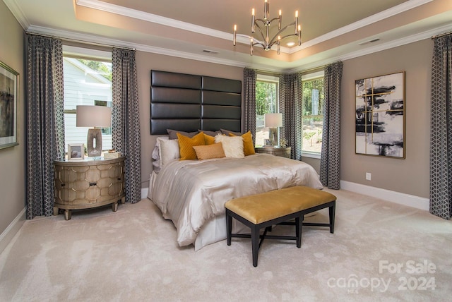 carpeted bedroom featuring an inviting chandelier, ornamental molding, and a raised ceiling