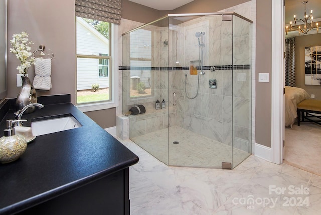 bathroom featuring vanity, an inviting chandelier, a healthy amount of sunlight, and walk in shower