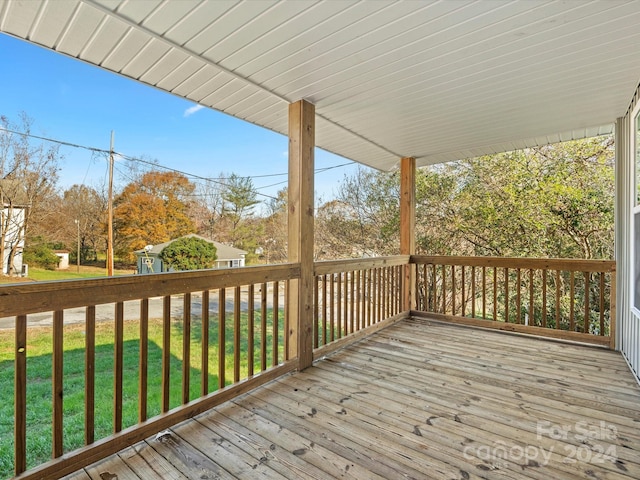 wooden deck featuring a lawn