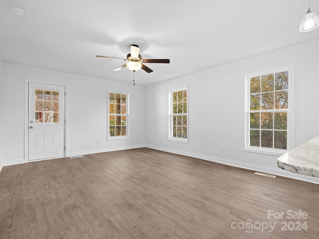 empty room with hardwood / wood-style floors and ceiling fan