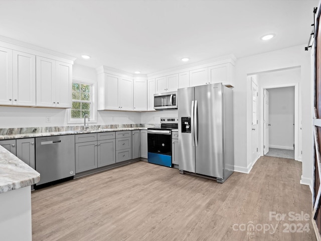 kitchen with gray cabinets, white cabinetry, and stainless steel appliances