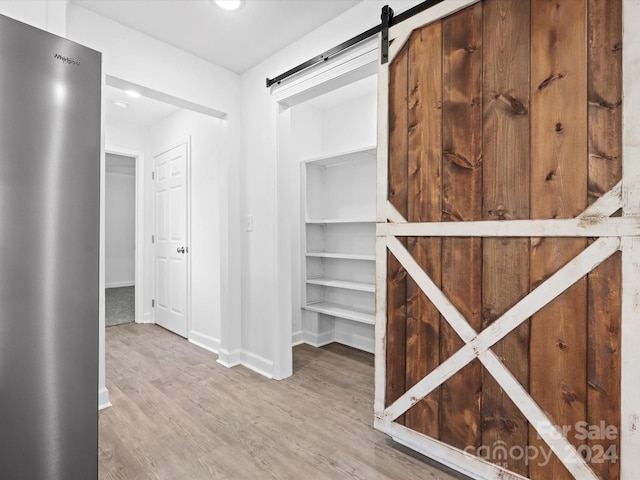 spacious closet featuring hardwood / wood-style floors and a barn door