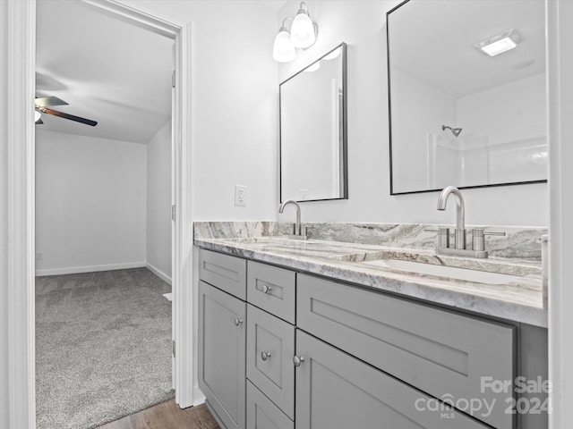 bathroom with hardwood / wood-style floors, ceiling fan, and vanity