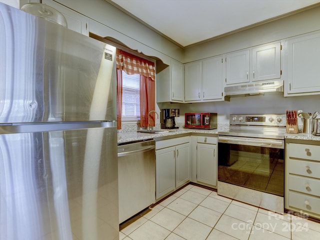 kitchen with light tile patterned floors, white cabinetry, sink, and appliances with stainless steel finishes