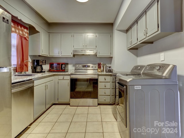 kitchen featuring stainless steel appliances, washer and clothes dryer, light tile patterned floors, gray cabinets, and sink