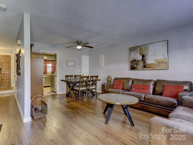 living room featuring ceiling fan and light hardwood / wood-style floors