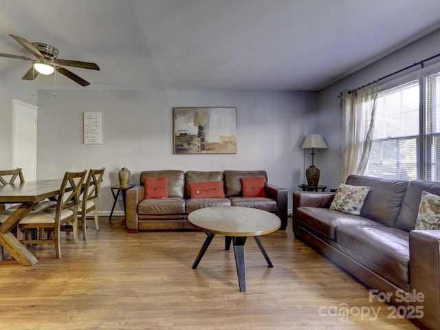 living room with light hardwood / wood-style flooring and ceiling fan