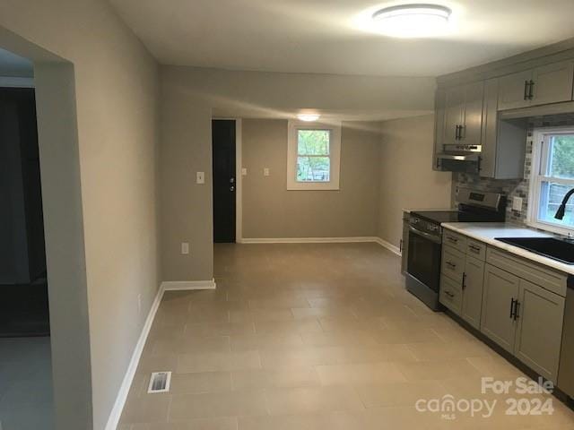 kitchen with stainless steel range with electric stovetop, plenty of natural light, gray cabinetry, and sink