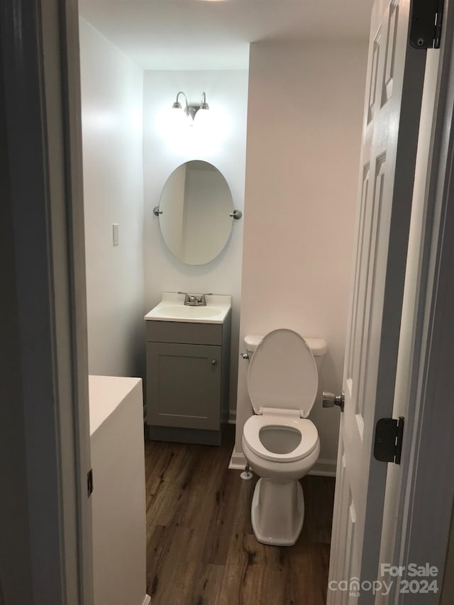 bathroom featuring vanity, hardwood / wood-style flooring, and toilet