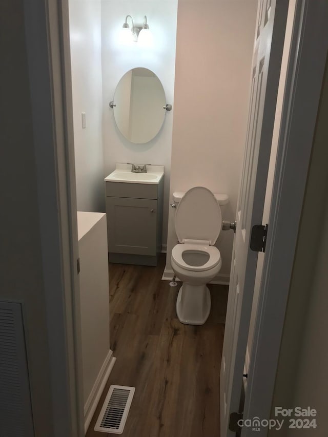 bathroom featuring vanity, hardwood / wood-style flooring, and toilet