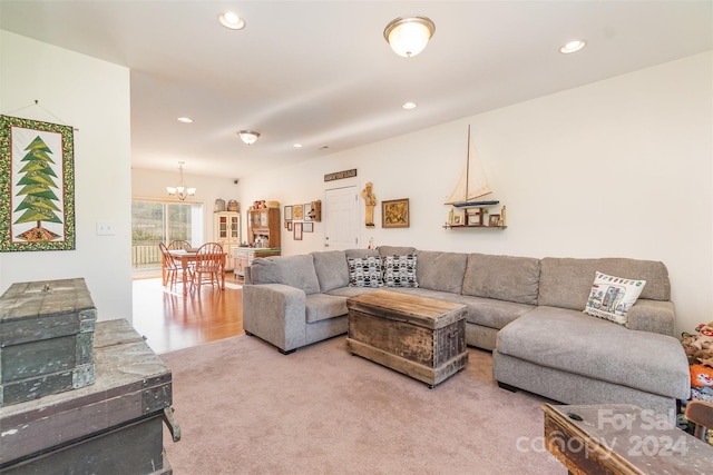 carpeted living room with a chandelier