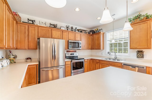 kitchen featuring pendant lighting, sink, and stainless steel appliances