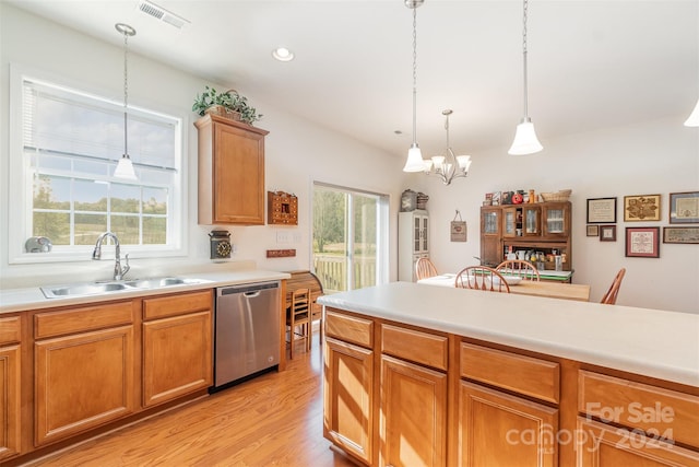 kitchen with sink, dishwasher, hanging light fixtures, and a healthy amount of sunlight