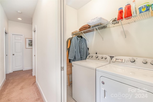 clothes washing area featuring washer and dryer and light colored carpet