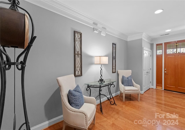 sitting room with light hardwood / wood-style flooring and ornamental molding