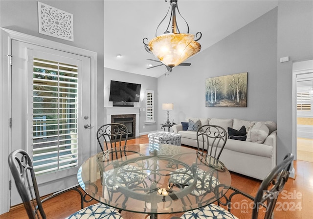 dining room with hardwood / wood-style floors, a chandelier, and vaulted ceiling